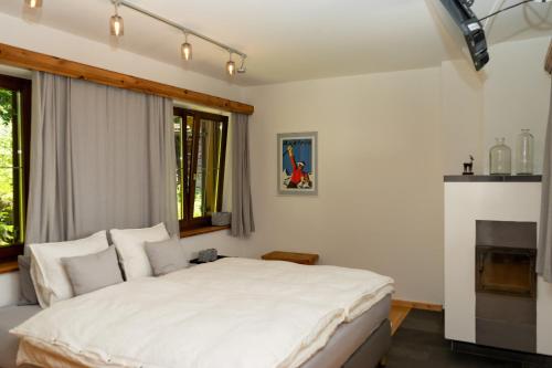 a bedroom with a white bed and a fireplace at Landhaus Waldhof am Grossvolderberg in Volders