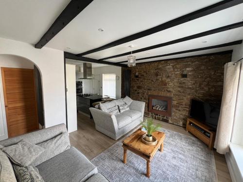 a living room with a couch and a fireplace at Sea Anchor Saundersfoot in Saundersfoot
