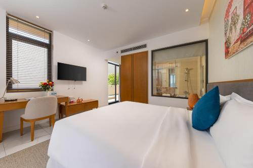 a bedroom with a large white bed and a desk at Green Garden villa in Cam Lâm