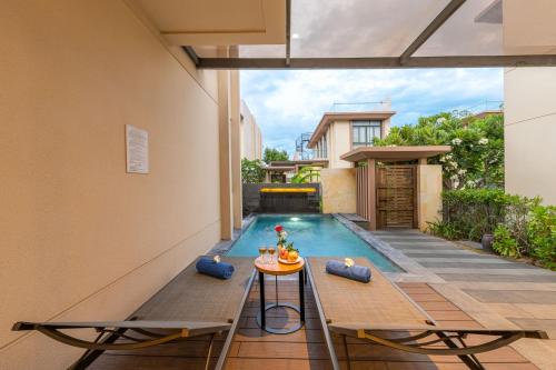 a backyard pool with a table next to a house at Green Garden villa in Cam Lâm