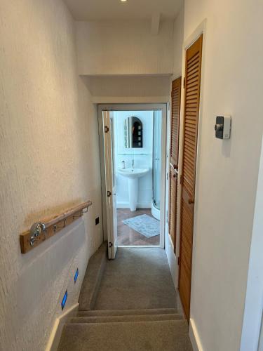 a hallway leading to a bathroom with a sink at Sea Anchor Saundersfoot in Saundersfoot