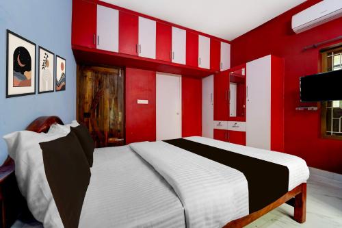 a bedroom with red and white walls and a bed at Collection O Balaramapuram White Castle in Kovalam
