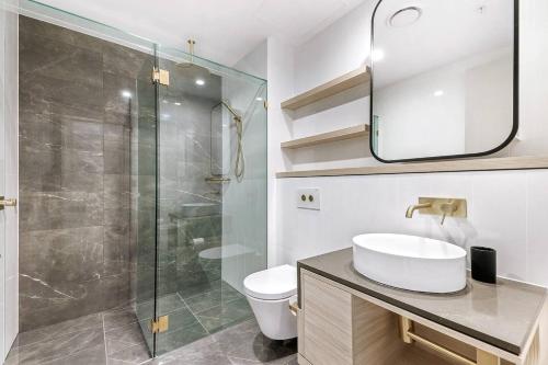 a bathroom with a sink and a glass shower at Sky-High Sanctuary Ocean Views - Pet Friendly in Gold Coast