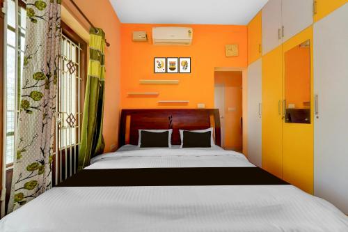 a bedroom with a bed with an orange wall at Collection O Balaramapuram White Castle in Kovalam