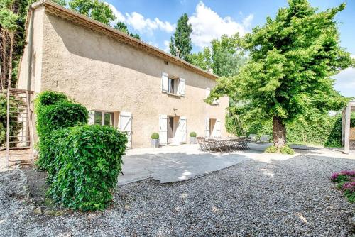a house with a hedge in front of it at Avignon Grand Mas XXL avec Piscine, parc et Mazet in Avignon