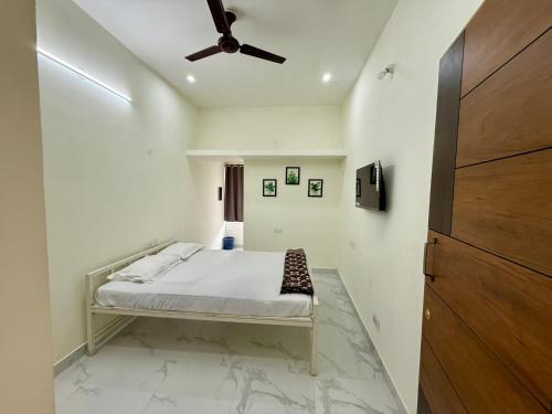 a bedroom with a bed with a ceiling fan at AVANI Stays in Yelagiri
