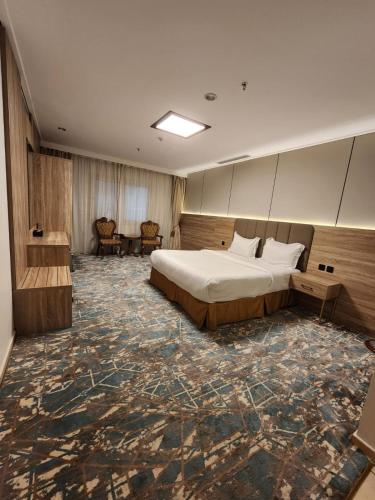 a hotel room with a bed and a large rug at Sadeem Al Fajr Hotel Suites in Taif