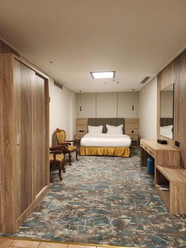 a hotel room with a bed and a couch and a table at Sadeem Al Fajr Hotel Suites in Taif