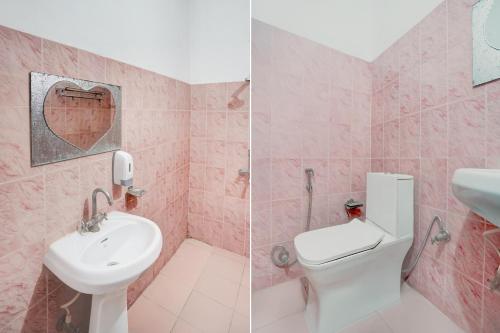 a pink bathroom with a sink and a toilet at Collection O Krishna Nagar Chowk Near ONGC in Dehradun
