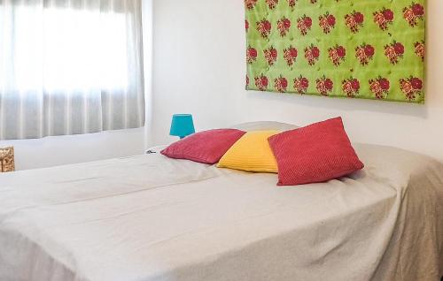 a bed with two red and yellow pillows on it at Casetta San Giovanni in Giuliana