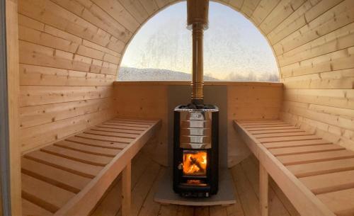 a sauna with a wood stove in a window at Cabin with Sauna and Aurora Views in Karlsøy