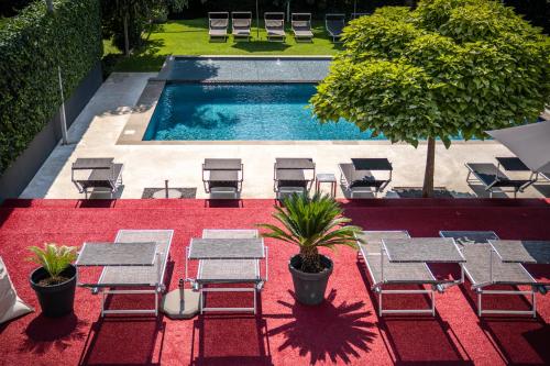 a swimming pool with chairs and a table and a swimming pool at goldfinger + suites in Lana