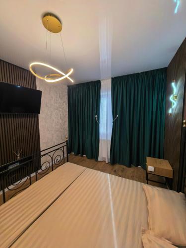 a bedroom with a bed and green curtains at Atractiv Two Luxury in Dudu