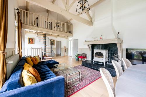 a living room with a blue couch and a fireplace at Campagne et bien être - Collection Idylliq in Villiers-sous-Grez