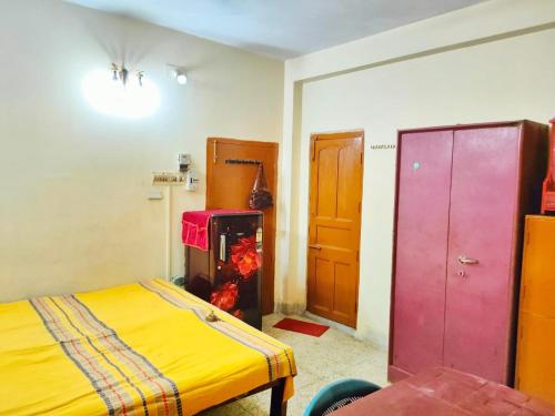 コルカタにあるSubarnarekha Apartment, Bijoygarh, Kolkataの黄色のベッドとピンクのクローゼットのある寝室