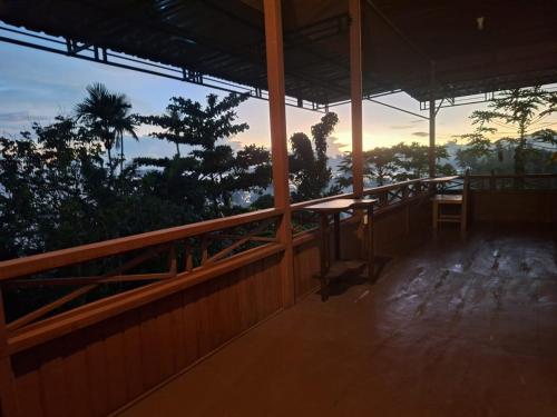 a balcony of a house with a sunset in the background at Raja Ampat Koba-koba Guest House in Waisai