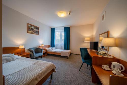 a hotel room with a bed and a desk at Nova Hotel in Radom