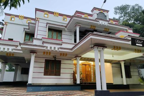a large white building with columns and windows at Collection O Balaramapuram White Castle in Kovalam