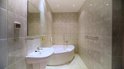 a bathroom with a sink and a bath tub at Nova Hotel in Radom