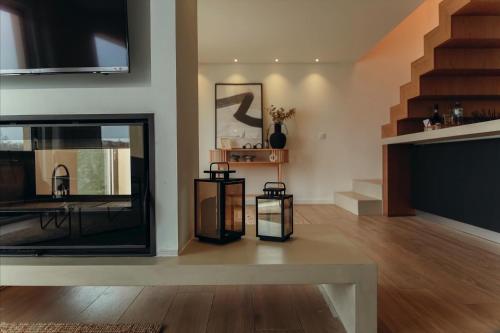Una sala de estar con chimenea y televisión. en Villa Gerês Emblematico - Piscina & Jacuzzi, en Venda Nova