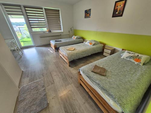 a room with three beds and a green wall at Pokoje Bema 14 in Ciechocinek