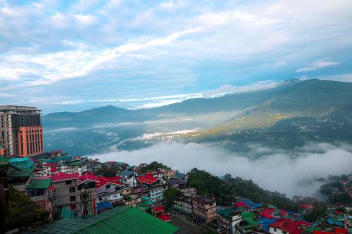 a view of a city with fog in the valley at Evara Hills, Gangtok in Gangtok