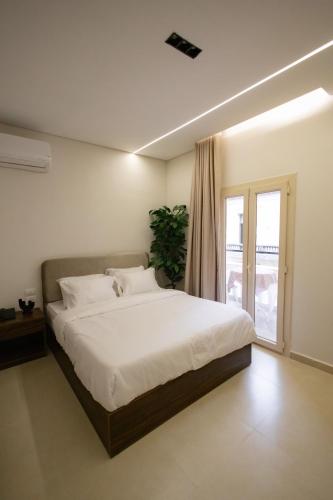 a bedroom with a large white bed and a window at Imperial Luxury Hotel in Cairo