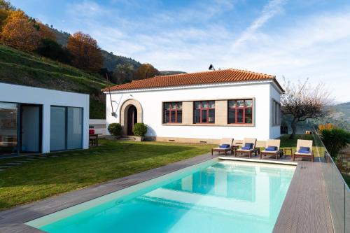 a villa with a swimming pool in front of a house at Spacious Villa with Private Pool & Garden in Douro, by Hopstays in Sabrosa