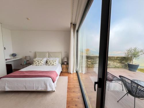 a bedroom with a bed and a sliding glass door at NEW!! Lugar das Letras in Sabrosa