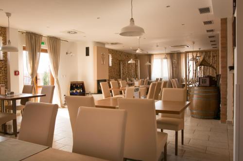 a restaurant with tables and chairs and a barrel at Penzión u Vinára in Veľký Krtíš