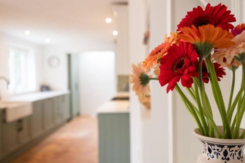 a vase filled with flowers on a counter in a kitchen at The Bantams, Monk Soham in Bedfield
