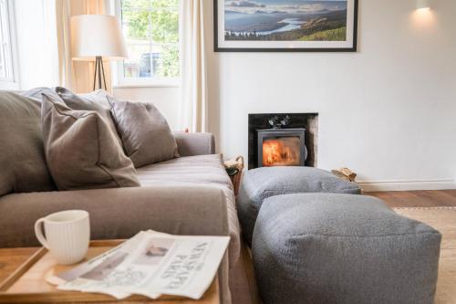 a living room with a couch and a fire place at The Bantams, Monk Soham in Bedfield