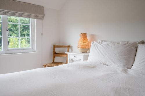 a bedroom with a white bed and a window at The Bantams, Monk Soham in Bedfield
