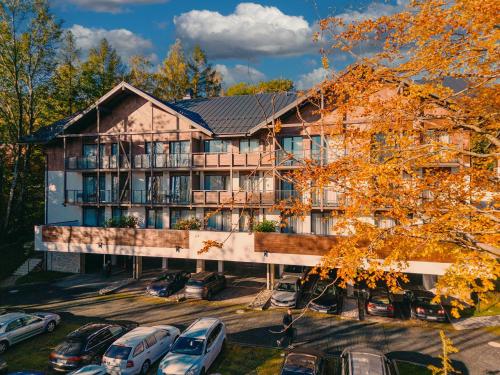 an apartment building with cars parked in a parking lot at Elements Apartments in Świeradów-Zdrój