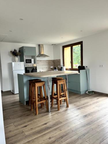 a kitchen with a counter and stools in a kitchen at Gîte du Nant in Sainte-Agnès