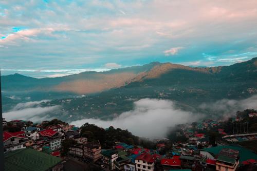a view of a city with fog in the mountains at Evara Hills, Gangtok in Gangtok