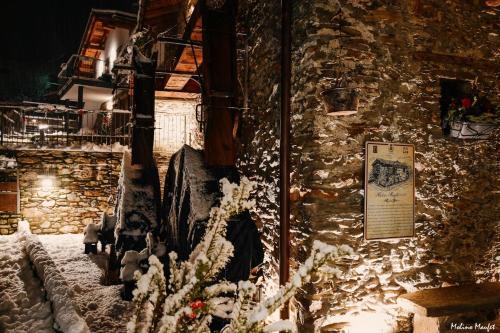 a stone building with snow on the side of it at Il Granaio - Historic Molino Maufet Watermill - Lake Como in Colico