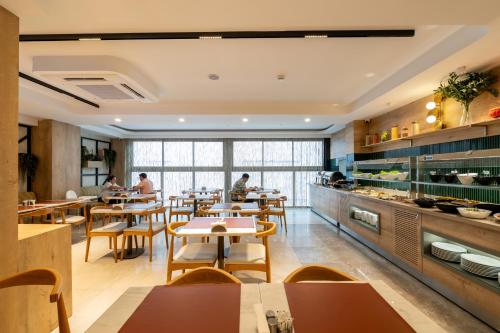 a restaurant with tables and people sitting at tables at Alves Hotel in Konak