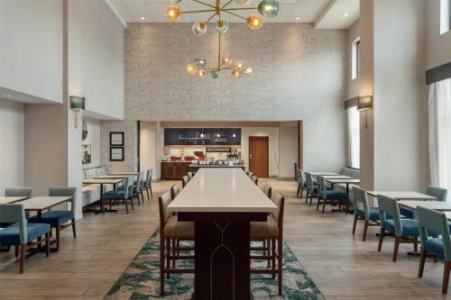 タンパにあるHampton Inn & Suites by Hilton Tampa Busch Gardens Areaのテーブルと椅子とシャンデリアのあるダイニングルーム