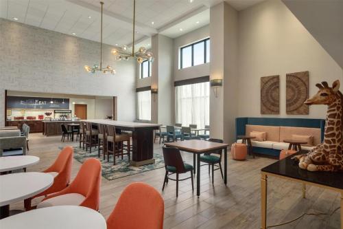 a restaurant with a giraffe on a table and chairs at Hampton Inn & Suites by Hilton Tampa Busch Gardens Area in Tampa