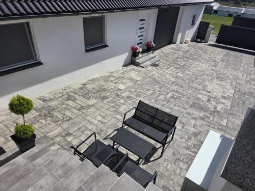 a patio with two black chairs and a bench at Napoli sobe in Sveti Ivan Žabno