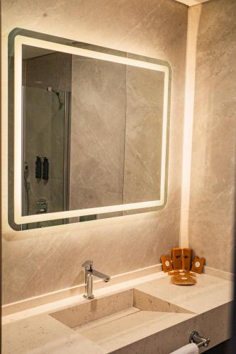 a bathroom with a sink and a large mirror at Alves Hotel in Konak