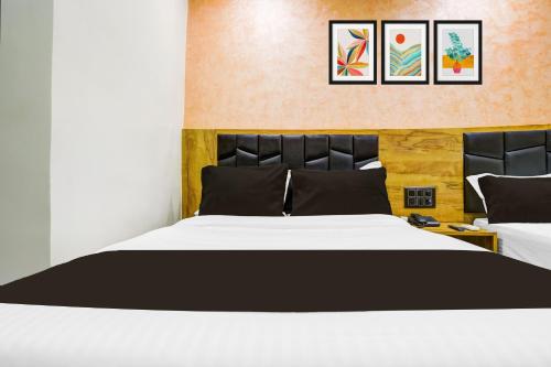 a bedroom with a large white bed and two pictures on the wall at Collection O Santacruz Khar Subway in Mumbai