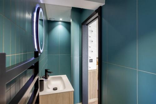 a bathroom with blue walls and a sink and a mirror at Casa Miot in Bastia