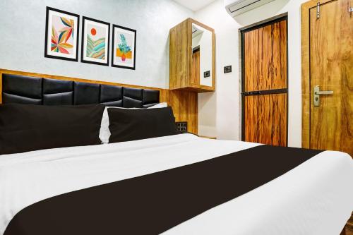 a bedroom with a bed and a wooden door at Collection O Santacruz Khar Subway in Mumbai