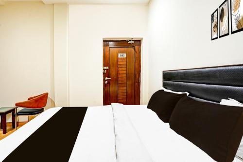 a bedroom with a large bed and a wooden door at Hotel O Gurudwara Square in Gwalior