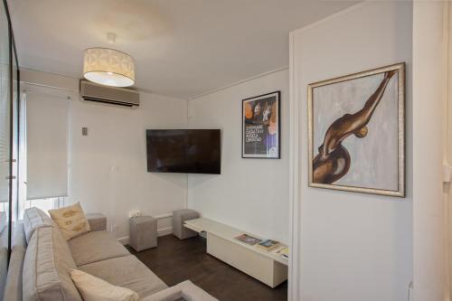 a living room with a couch and a tv at Lucamare - Casa Rossa in LʼÎle-Rousse