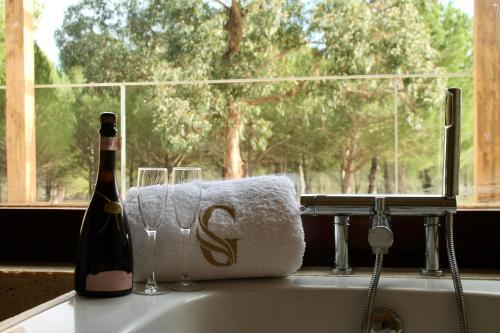 a bottle of champagne and a towel and a bottle of wine at Green Gold Passion in Santo Estêvão