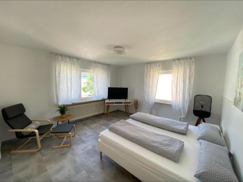 a bedroom with two beds and a tv and a chair at Haus Schwarzwald - Bad Krozingen in Bad Krozingen