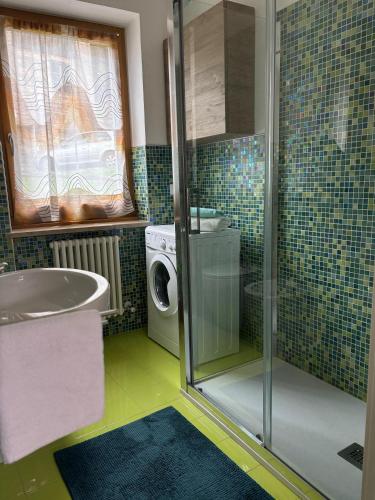 a bathroom with a sink and a washing machine at Casa Latemar in Moena